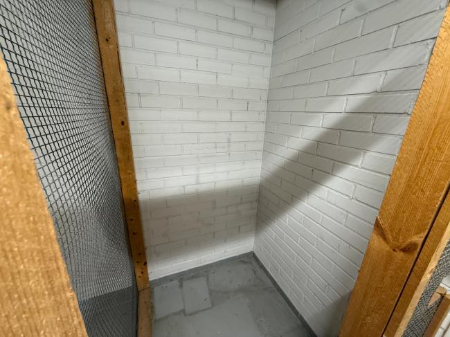 Vilhonkatu 5:n pienvarasto, valkoiset tiiliseinät ja lukittava verkko-ovi
